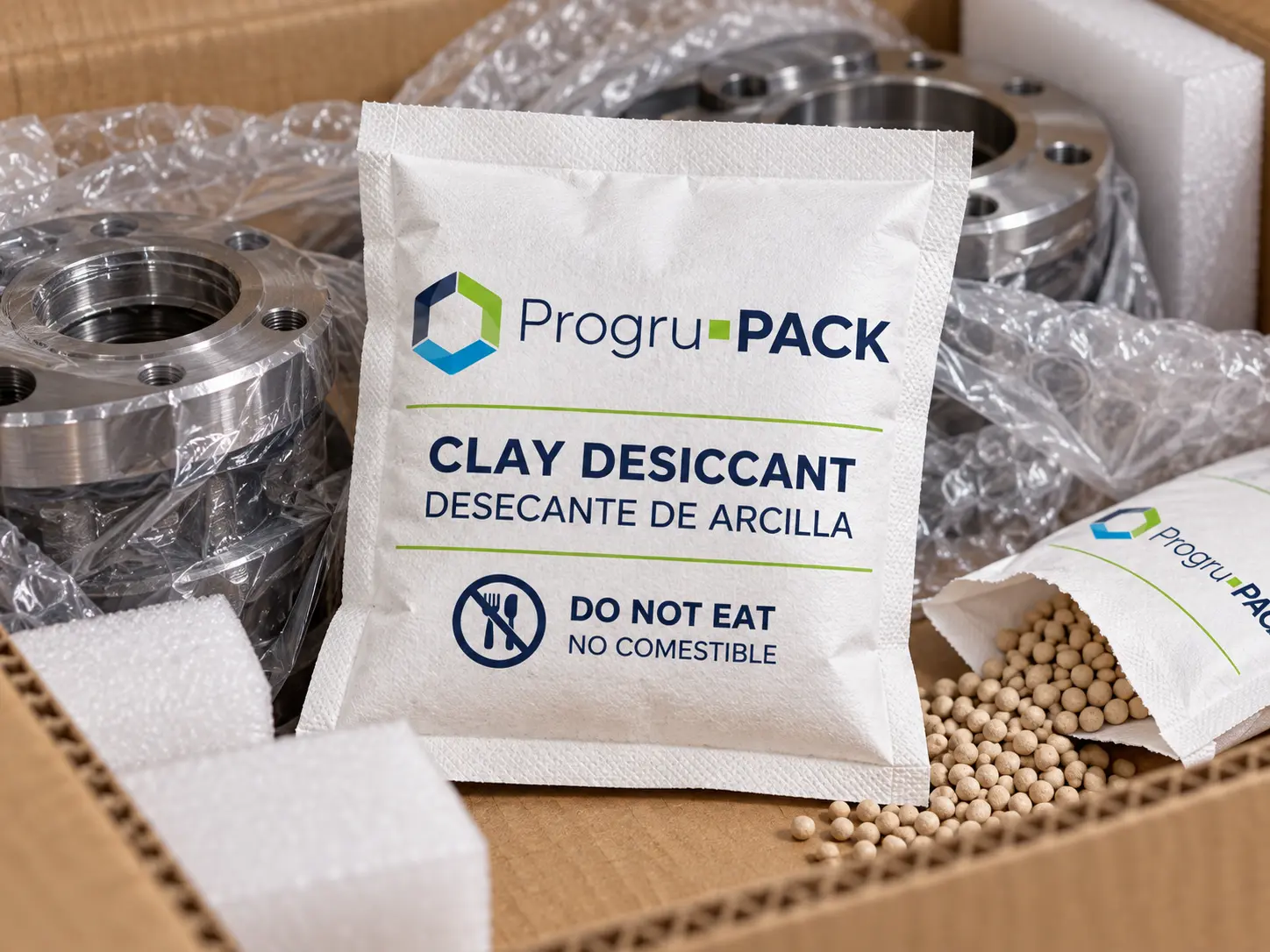 Sobre desecante clay junto a componentes metálicos en aplicación industrial